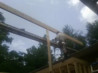 Carpenter setting a ridge beam over a new addition frame — Ice Dam Removal by Roofing Brothers in Pascoag