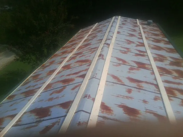 Rusted metal roof panels with new wood purlins before replacement — Storm Damage Roof Repair in Pascoag by Roofing Brothers